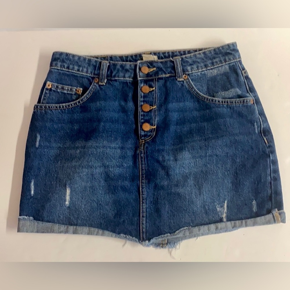Roxy-denim mini skirt with raw hem and manufactured distressing.Size 12
